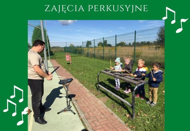 Na boisku szkolnym nauczyciel uczy grać przedszkolaki na padach